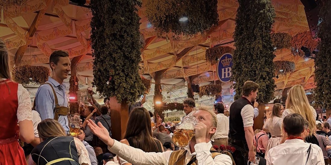 Downing a maß in lederhosen inside the Hofbräu tent