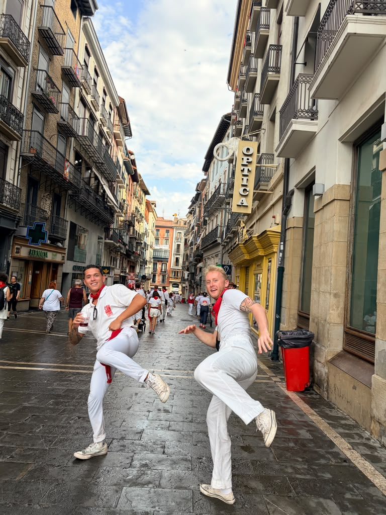 Runners in white and red on the cobbles of Pamplona